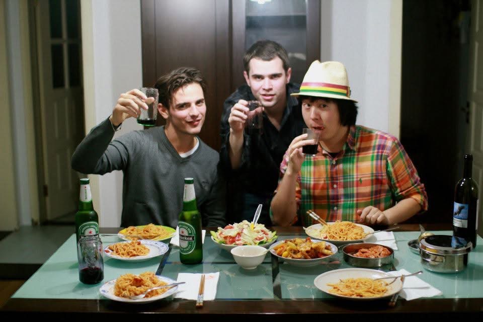 Young Filippo toasting over a spaghetti dinner with two friends in Shanghai